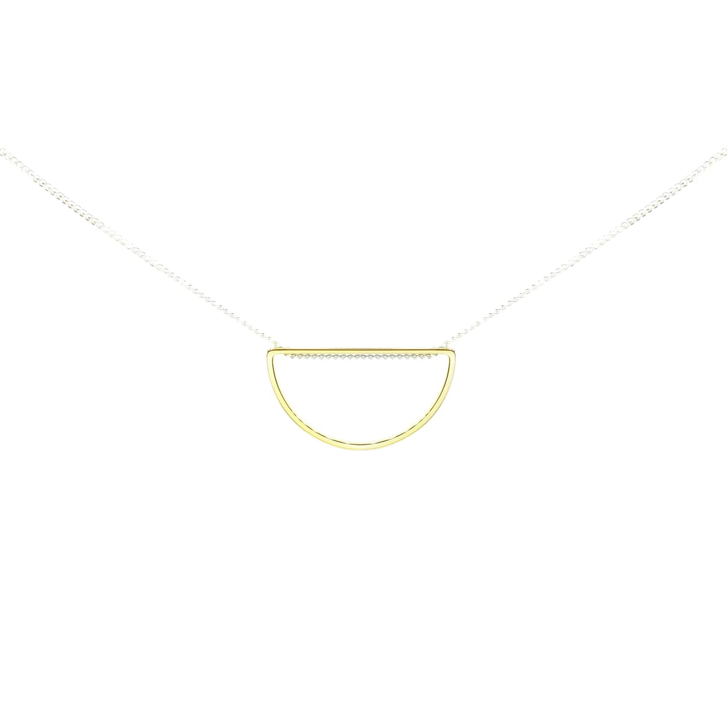 The Afternoon Light Necklace is a handmade mixed-metal piece featuring a thin silver chain and a small, open half-circle gold-plated brass pendant, beautifully displayed against a white background.