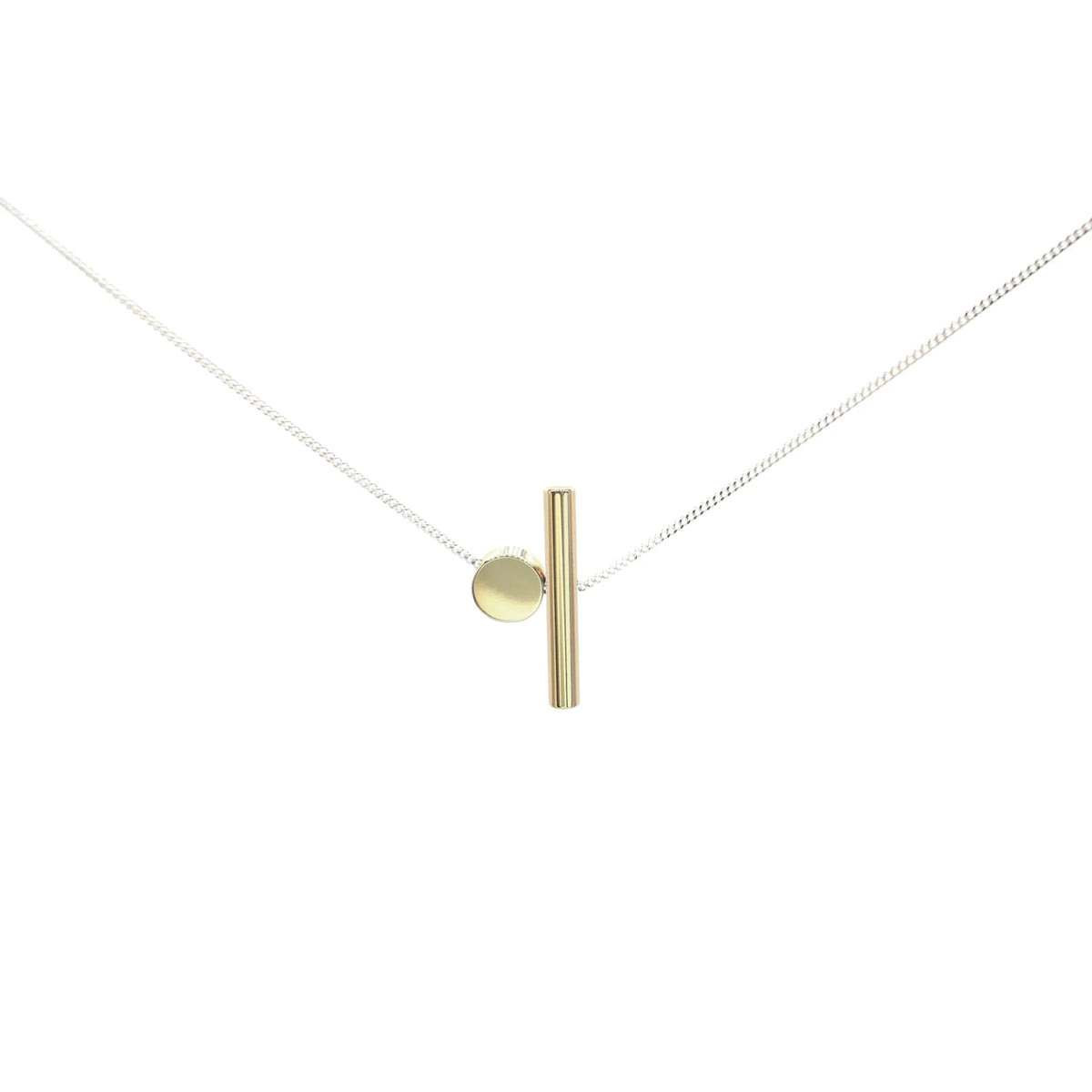 The Rock & A Hard Place Necklace is a minimalist mixed metal piece with a fine sterling silver chain, a small gold circle, and a vertical gold bar pendant—ideal for lovers of handmade jewelry.