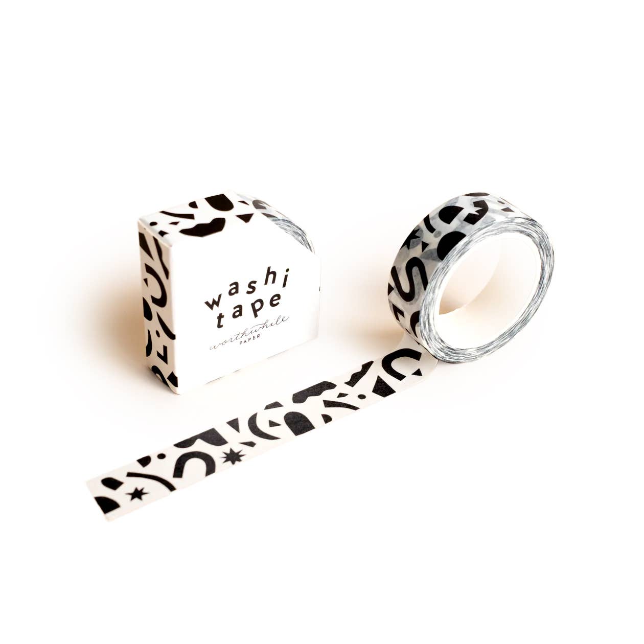 The Confetti Pattern Washi Tape, featuring abstract black confetti shapes on white, is partially unrolled beside its matching box labeled "washi tape" in bold black text—ideal for crafting projects.