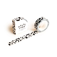 The Confetti Pattern Washi Tape, featuring abstract black confetti shapes on white, is partially unrolled beside its matching box labeled "washi tape" in bold black text—ideal for crafting projects.