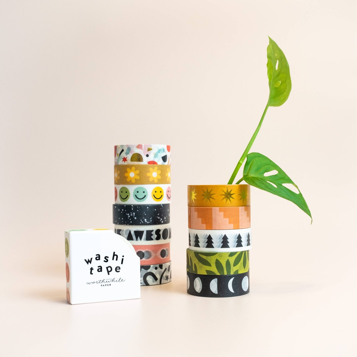 A stack of Lush Leaves Pattern Washi Tape rolls with vibrant patterns, a plant stem in one roll, and an eco-friendly white box labeled washi tape on a light background.