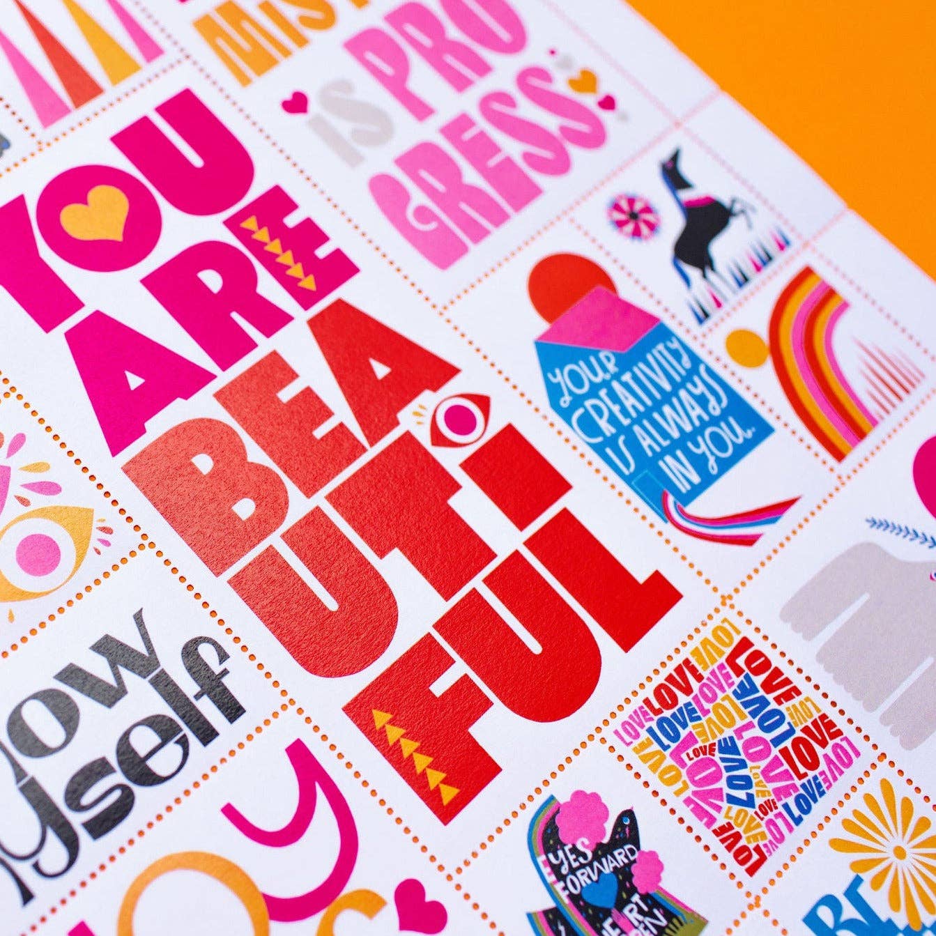 The Poster Stamp Series 7 | Hold It Lightly is a limited-edition Lisa Congdon poster featuring bold, uplifting phrases with vibrant graphics—hearts, eyes, rainbows, and stamp motifs arranged in a lively grid layout.