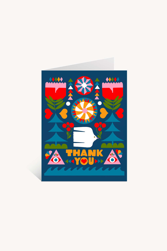 The Folk Flowers Thank You Greeting Card by Lisa Congdon features floral and geometric folk art, a white hand, red hearts, two eyes in triangles, and bold yellow “THANK YOU” letters on a deep blue background.