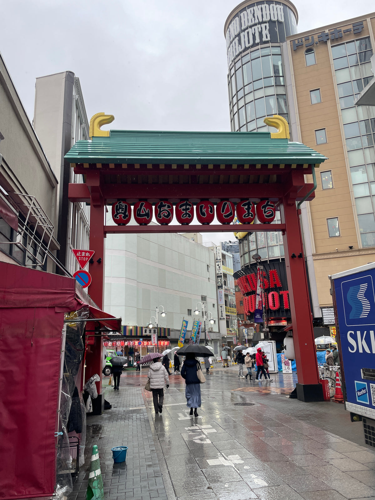 Experience the vibrant streets of Japan with our Japanese Mystery Box, inspired by scenes of bustling sidewalks near red torii gates, colorful city lights, and vendors selling unique gifts and travel souvenirs.