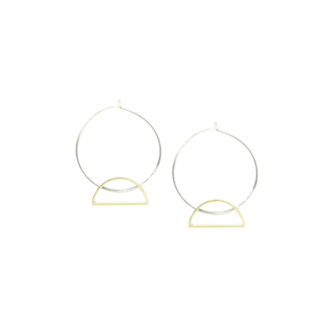 Setting Sun Earrings: Minimalist handmade jewelry from Cape Town, featuring large silver hoops with small gold semicircle accents—a striking accessory set against a plain white background.