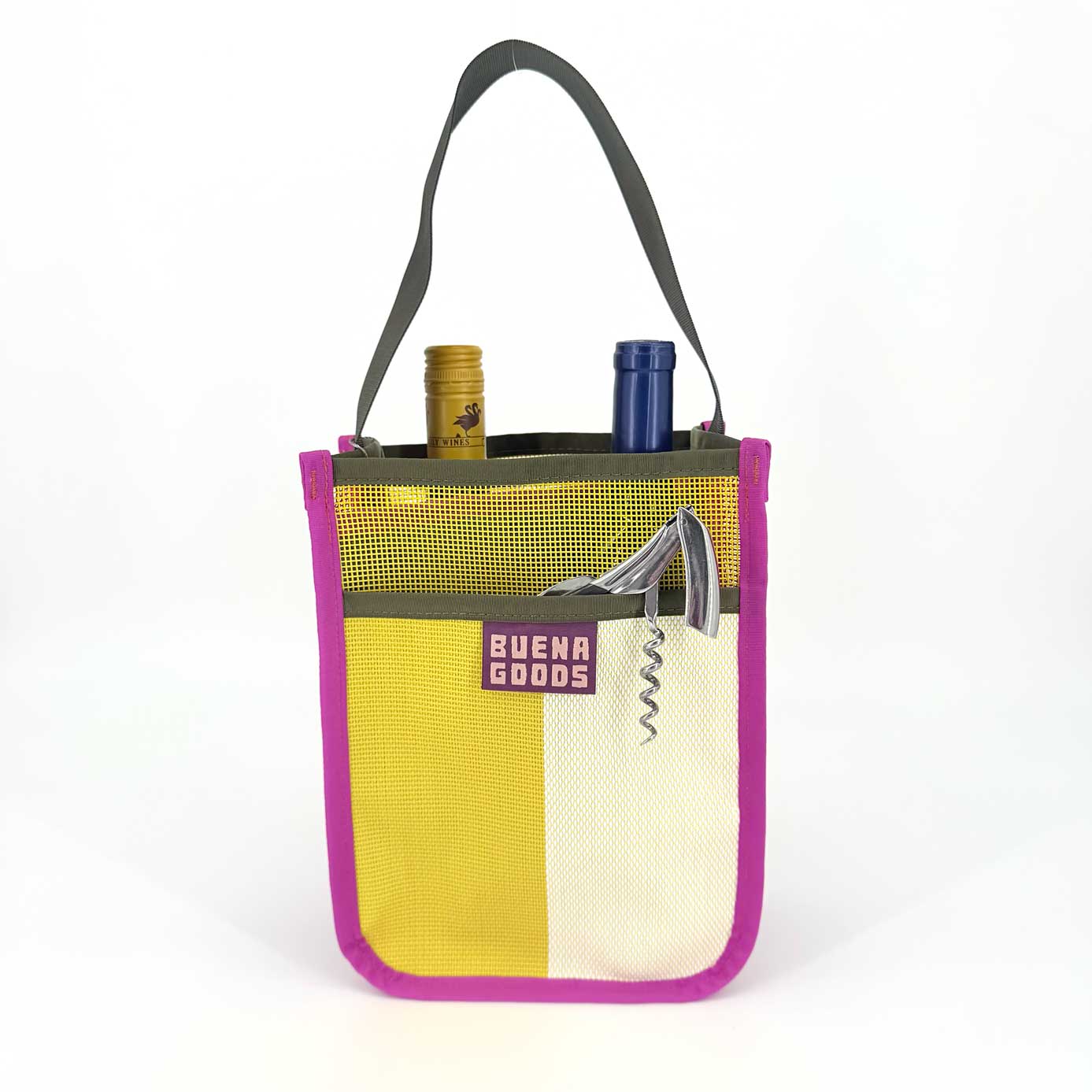 The Two-Bottle-Bag | Cava on the Playa is a yellow and white tote with pink trim, dark handle, and BUENA GOODS label. It holds two wine bottles plus a corkscrew in its front mesh pocket. Shown against a white background.