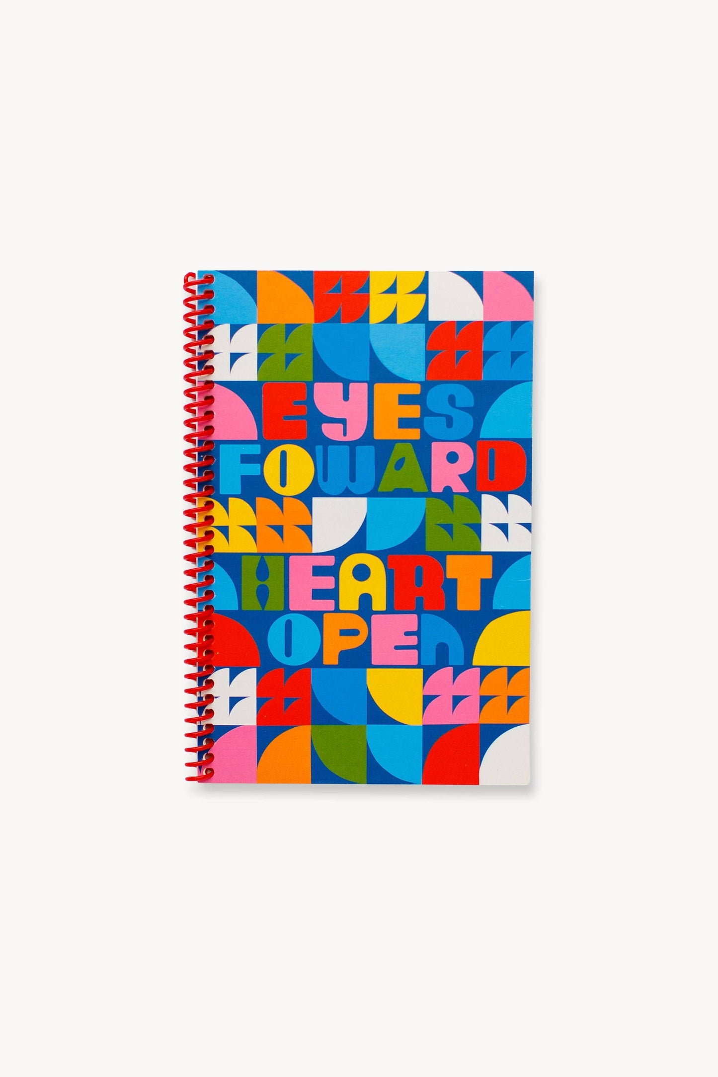 The Eyes Forward, Heart Open Journal is a vibrant spiral-bound notebook with a geometric cover and bold, multicolored "EYES FORWARD HEART OPEN" text, featuring an original illustration.
