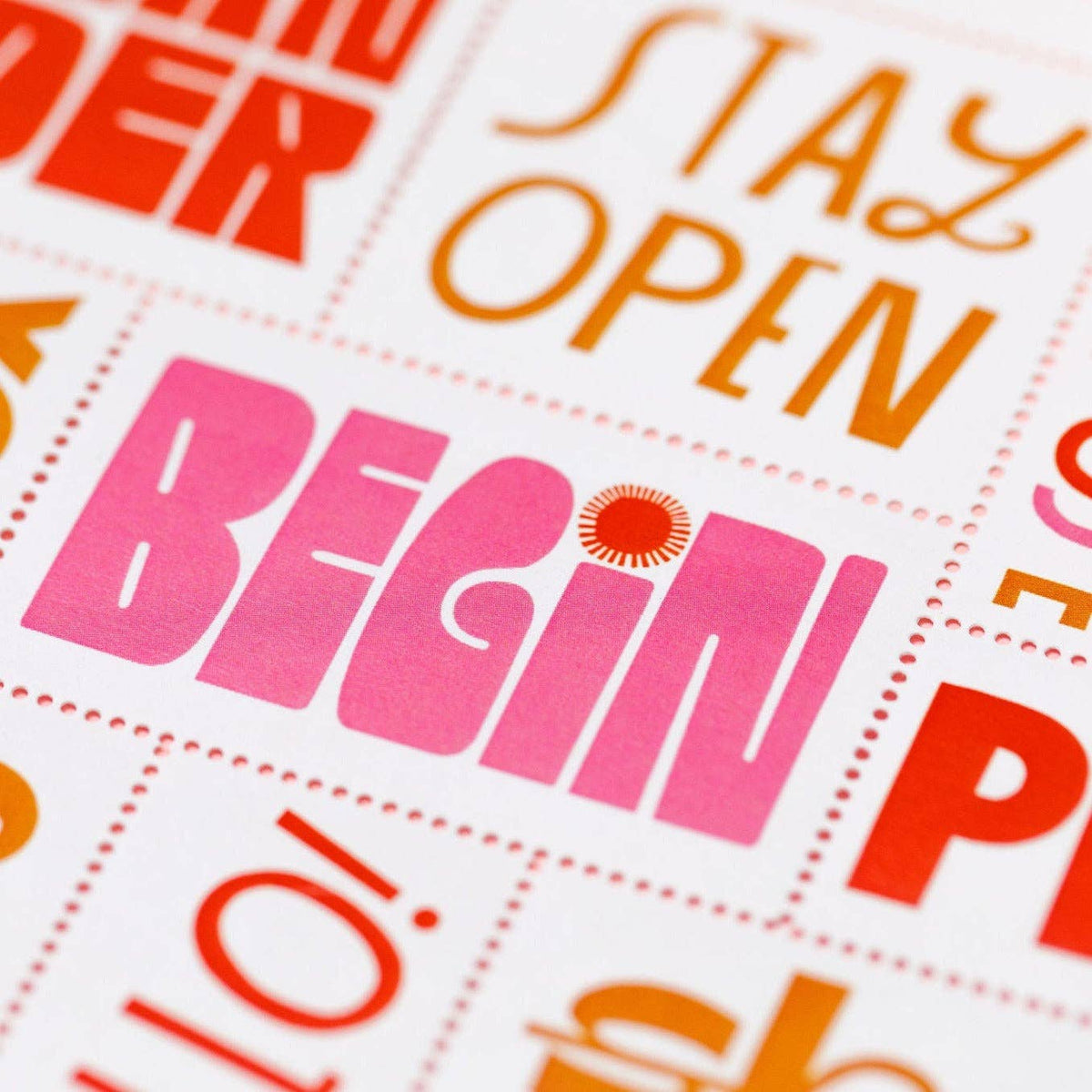 A close-up of Poster Stamp Series 5 | Words to Live By, a limited-edition sheet with motivational words in bold colors; BEGIN pops in large pink letters with a sunburst over the "I," echoing Lisa Congdon’s vibrant style.